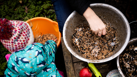Child mixing seeds outdoors