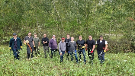 Work party standing together as they clear scrub at Chafford