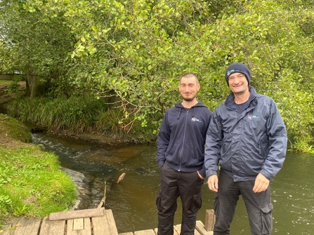 Ben (left) and Darren (right) from the Rivers Team standing in front of a river