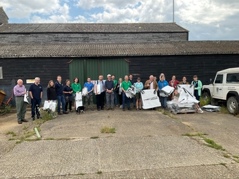 Team of people helping with recycling plastic tree guards at Abbotts