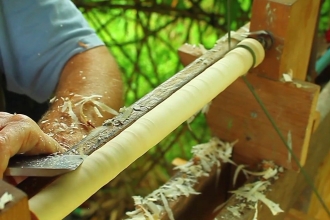 someone using a pole lathe to turn wood