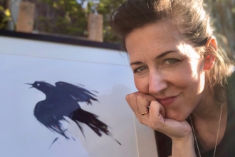 Portrait of Lucia Hardy with bird art work behind her