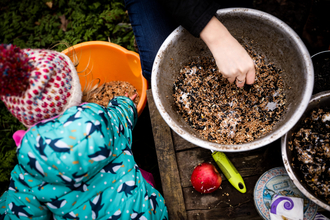 Child mixing seeds outdoors