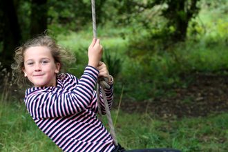 Child swinging on rope swing