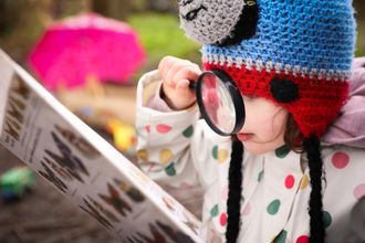 Child looking through magnifying glass