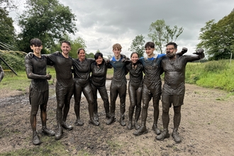 Carbon Numbers corporate group covered in mud after taking part in Running Wild