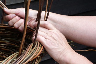 Photo of hands weaving willow