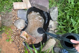 A mini pond being filled up with water.