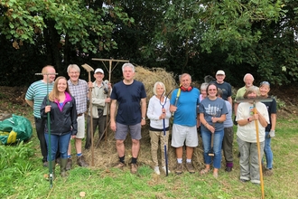 Team of volunteers posed with tools in The Meadow, Shenfield