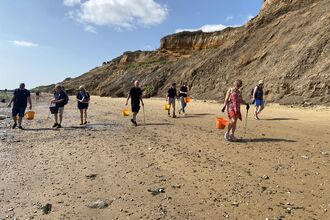 A group of people litter picking on a beach