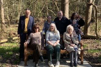 Photo of Jimmy Greaves' friends and family sat on bench installed at Fir Tree Wood