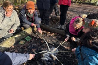 Women sat around woodfire 