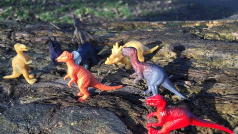 Toy dinosaurs on a log