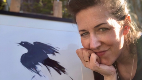 Portrait of Lucia Hardy with bird art work behind her