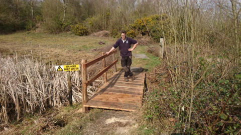 Ranger Alex, standing on a bridge on the reserve