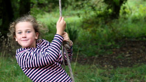 Child swinging on rope swing