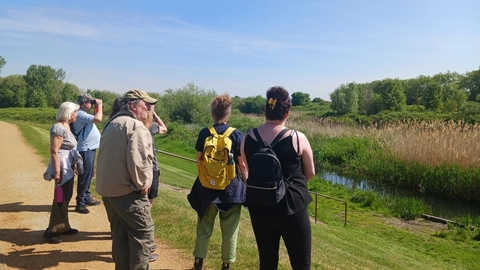 Small group of people looking at a lake