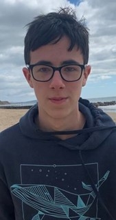 Arun standing on a beach, smiling at the camera