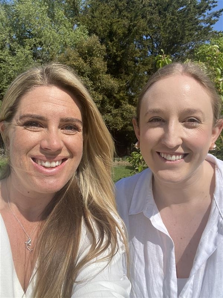 Lizzy (left) and Becky (right) taking a self portrait photograph in the garden.