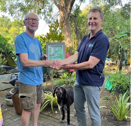 John Meehan and Jeremy Dagley holding a certificate and shaking hands. 