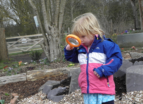 Toddler looking through magnifying glass